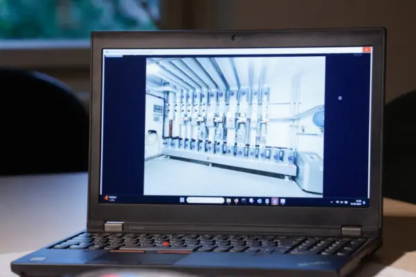Laptop zeigt das Foto eines Technikraums mit Rohrverteilern auf Bauplanunterlagen